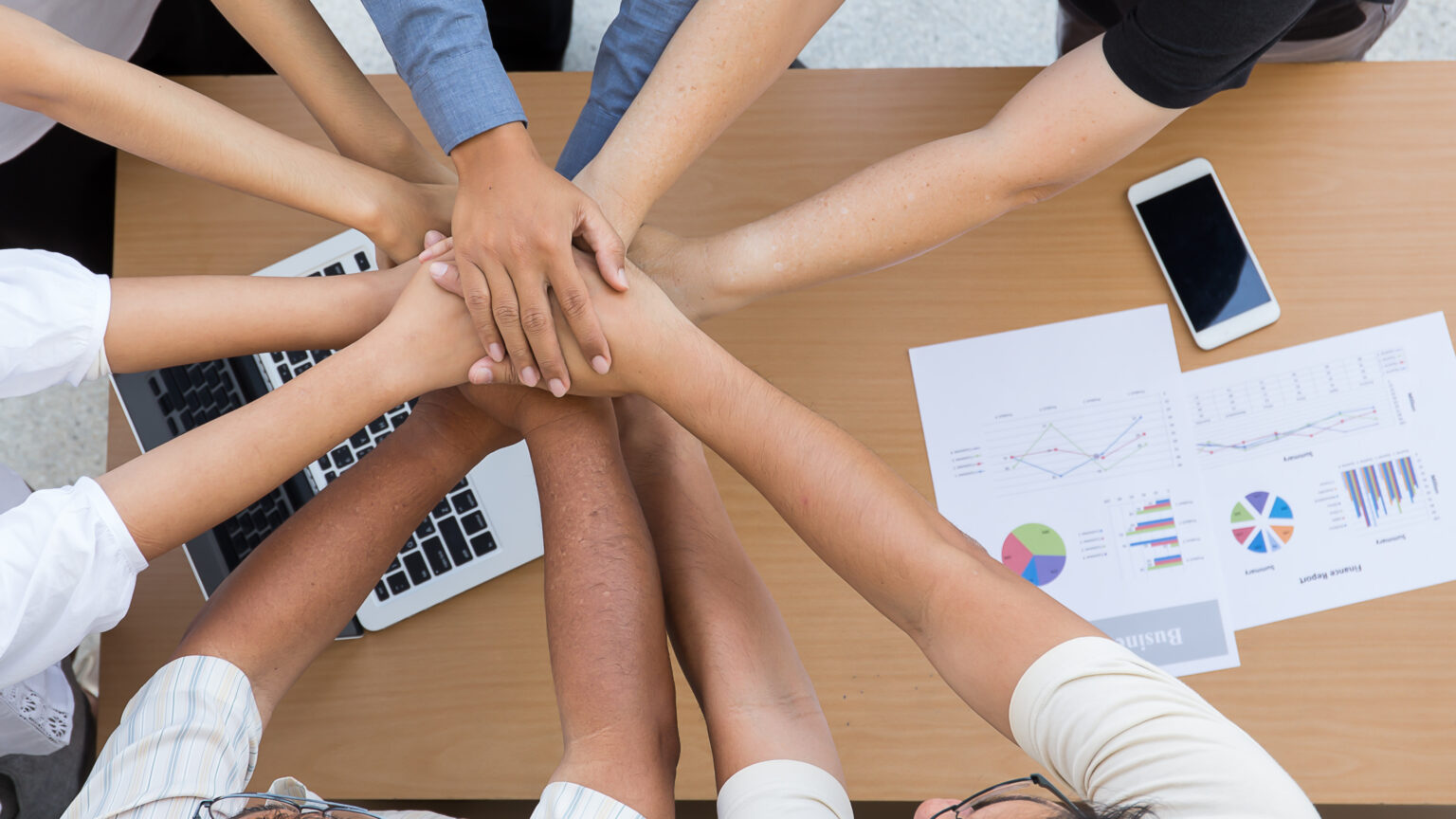 A huddle of hands from multiple ethnicities